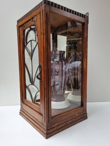 Oak Art Deco cabinet showcasing a purple glass vase against the mirrored back